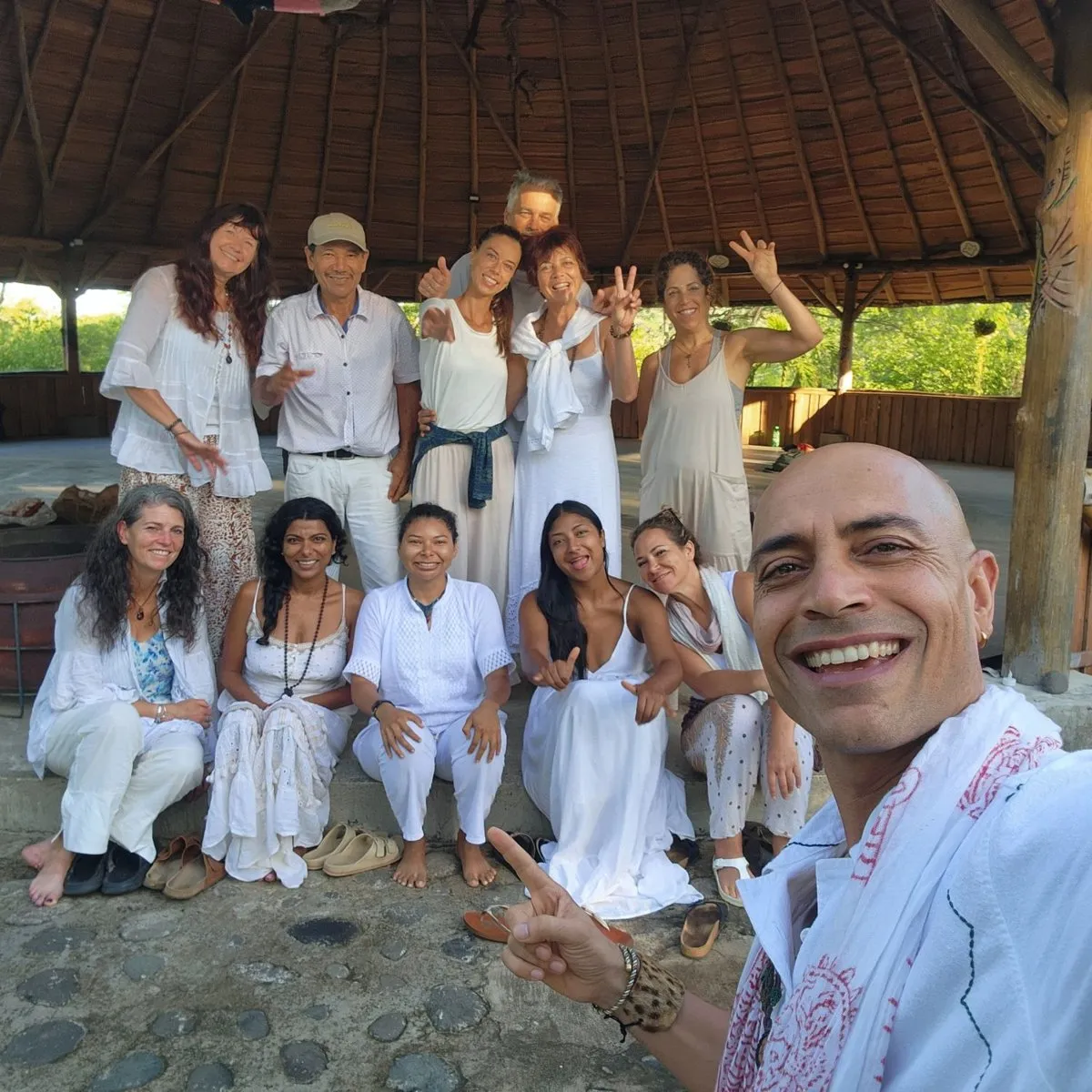 A group in white with Faisal under the maloka roof